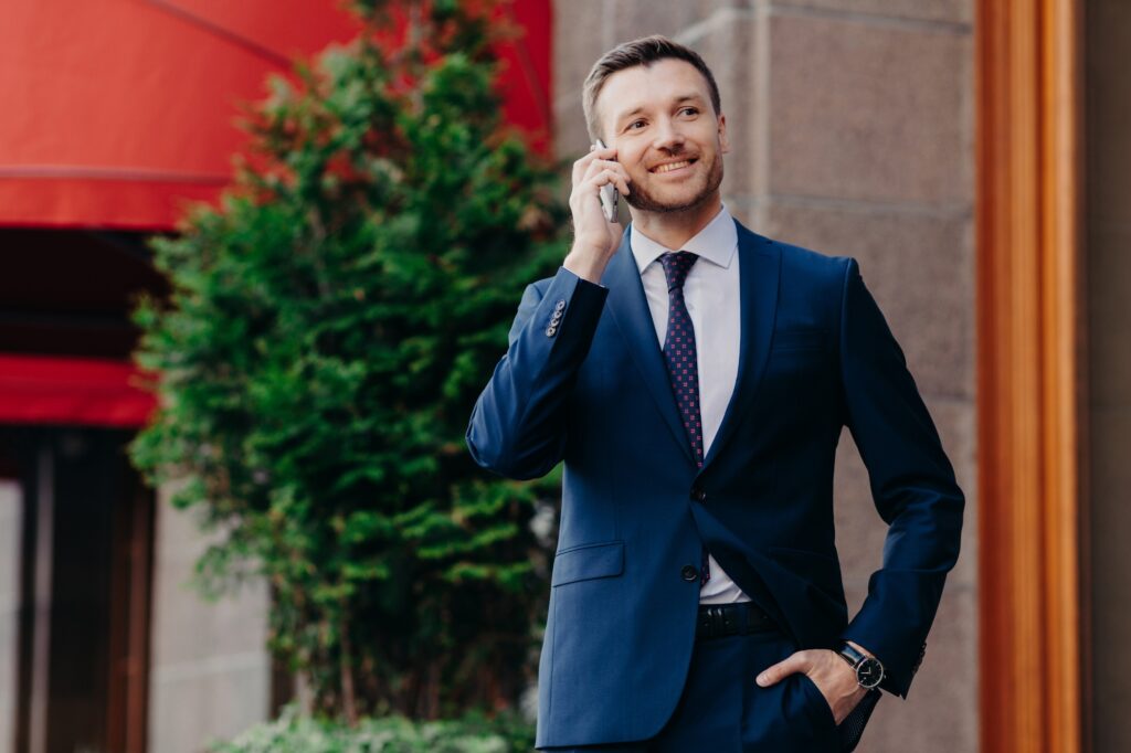 Optimistic male owner of buisness company dressed in elegant suit